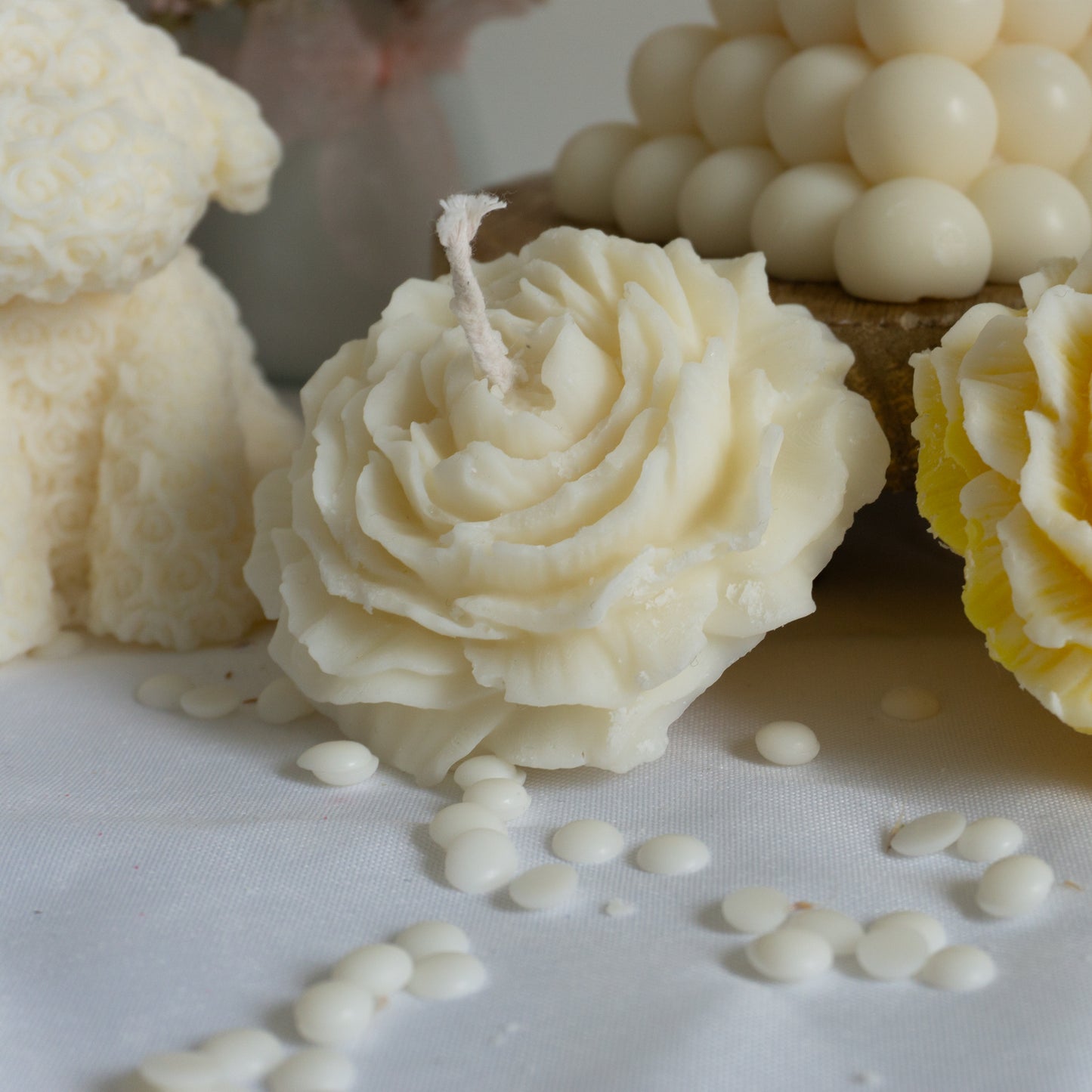 Photo de la bougie artisanale parfumée "pivoine" dans la couleur blanc à côté d'une autre bougie pivoine dans la couleur blanc 