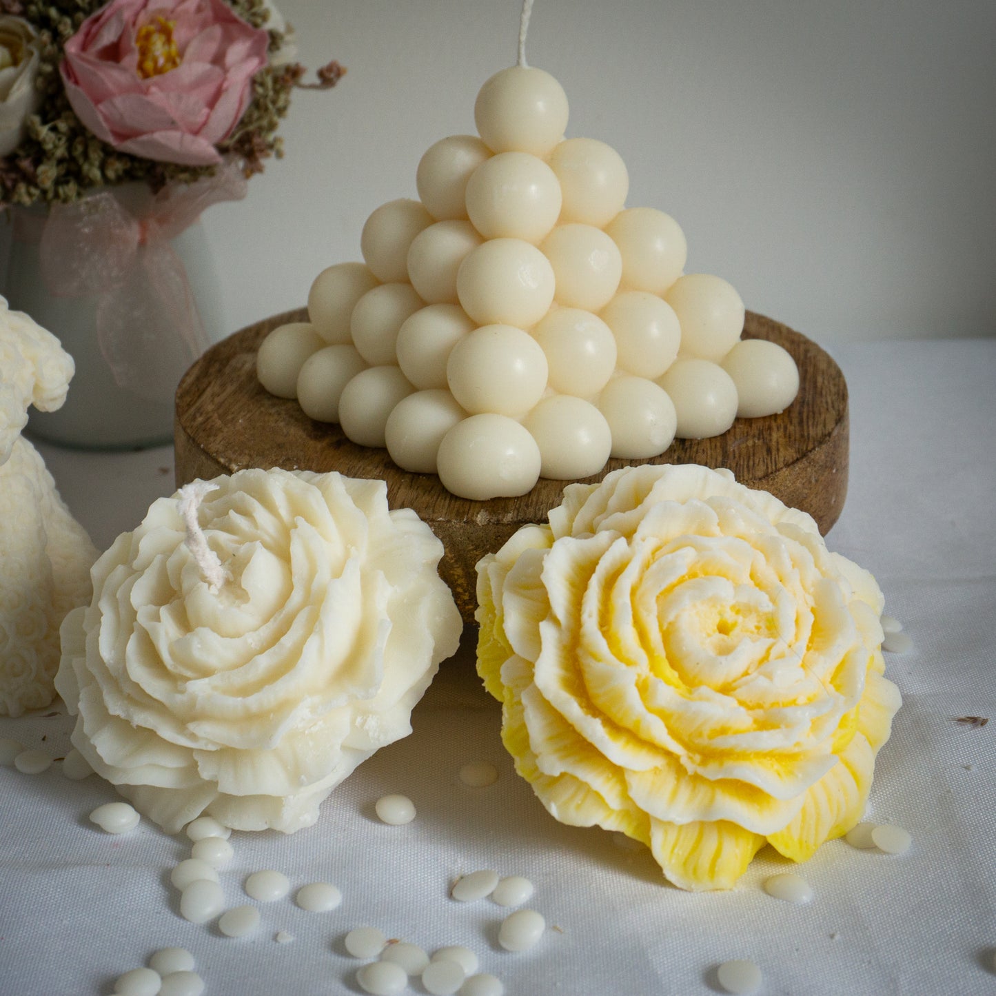 Photo de deux bougies artisanales parfumées "pivoine" une jaune et l'autre blanc